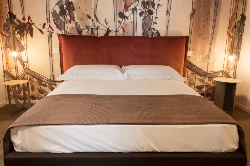 een slaapkamer met een groot bed met een houten hoofdeinde bij MONACHILE APARTMENTS in Polignano a Mare