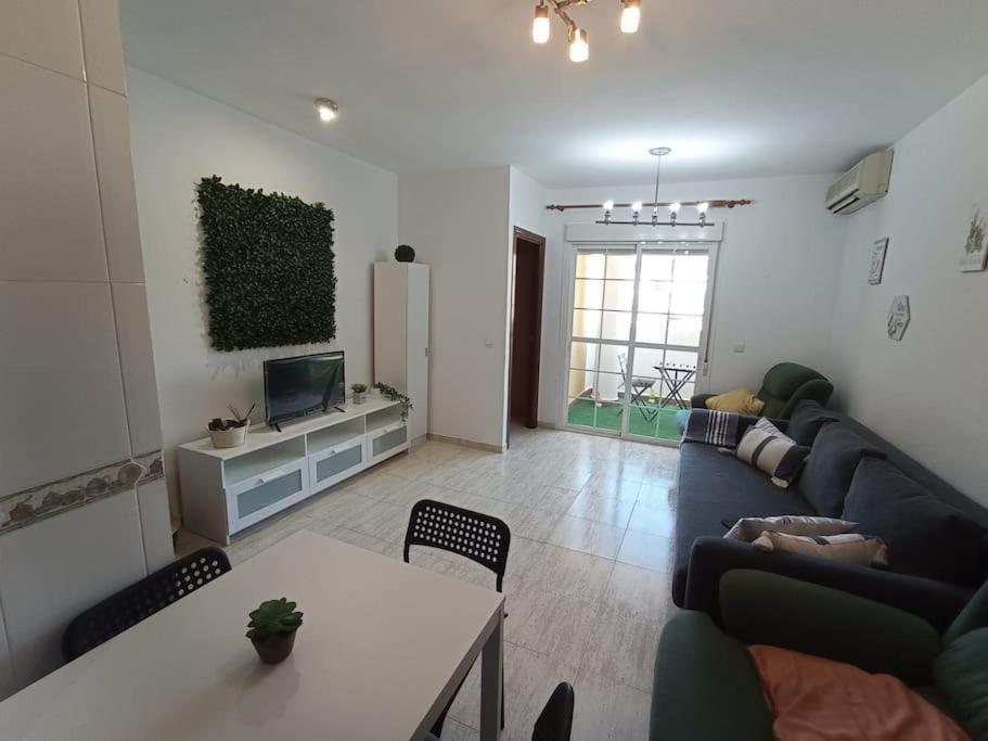 a living room with a couch and a table at Precioso piso con piscina a 10 min de la playa andando in Roquetas de Mar