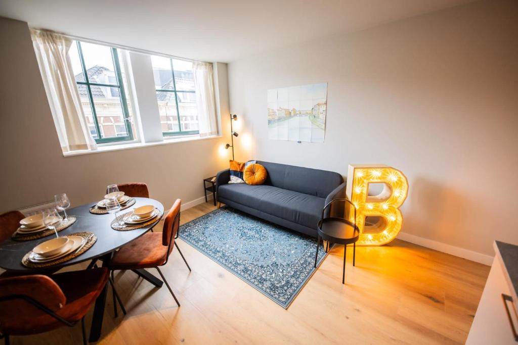 - un salon avec un canapé bleu et une table dans l'établissement Balanced 3 Bedroom Serviced Apartment 68m2, à Rotterdam
