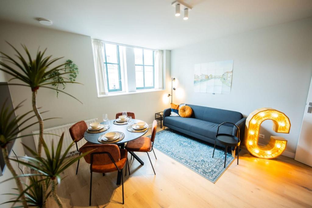 uma sala de estar com um sofá azul e uma mesa em Cool 3 Bedroom Serviced Apartment 68m2 em Roterdã