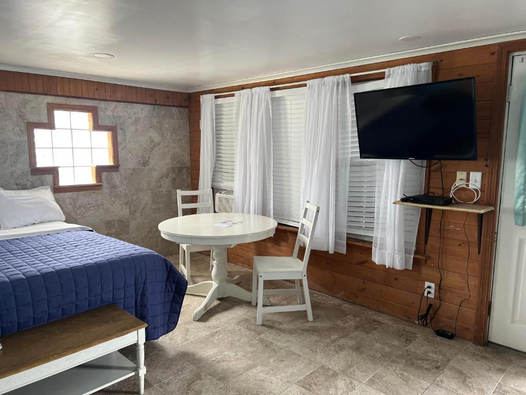 una camera con letto, tavolo e TV di Nautical Motel a Hampton Beach