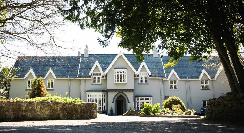 a large white house with a blue roof at The Broadmead Boutique B&B in Tenby