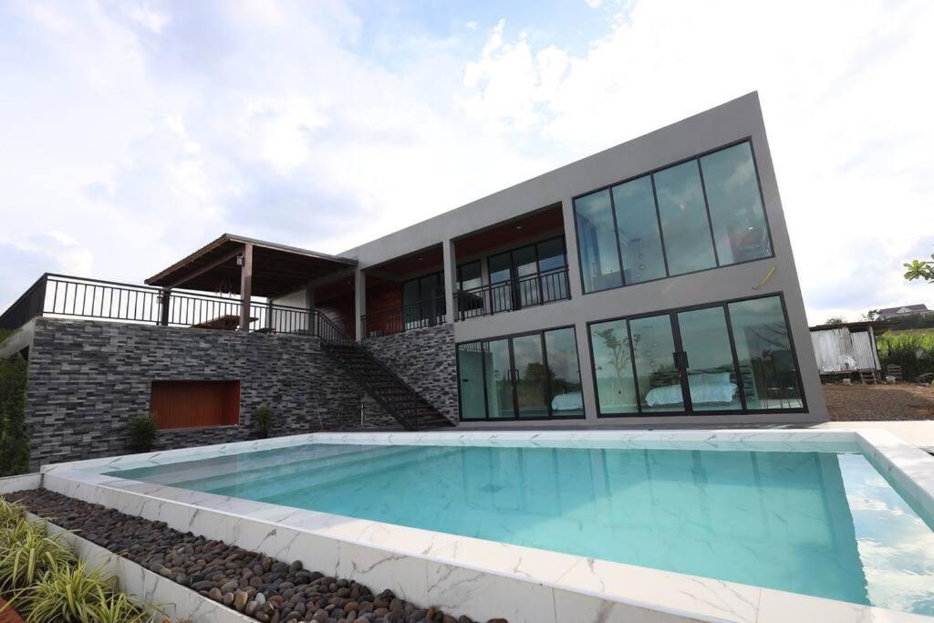 a house with a swimming pool in front of it at Million Stars Poolvilla in Wang Nam Khieo