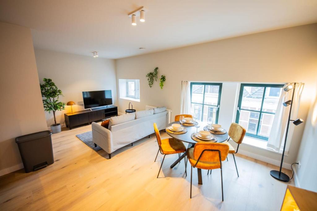 ロッテルダムにあるDeluxe 3 Bedroom Serviced Apartment 73m2のリビングルーム(テーブル、椅子、ソファ付)