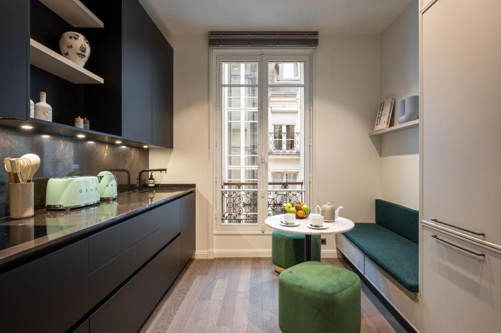 a kitchen with a table and a green chair at The very central location allows you to go everywhere in Paris in 30 minutes in Paris