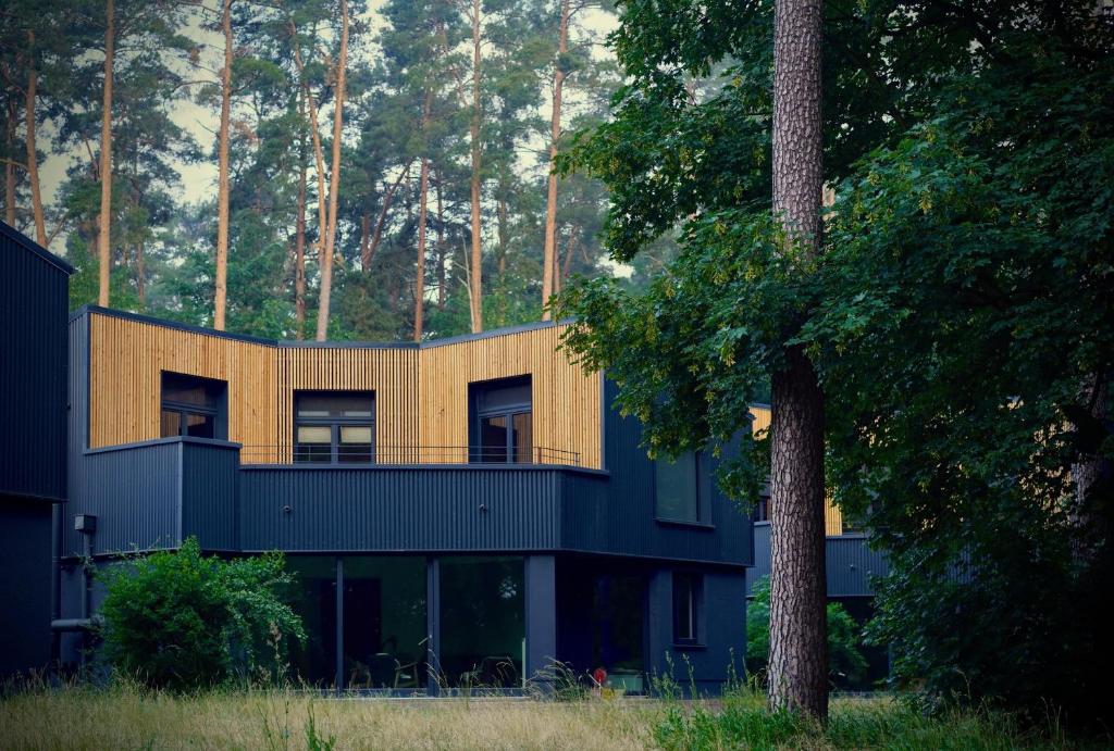 a house in the middle of a forest at Elf am See - Haus 7 in Templin