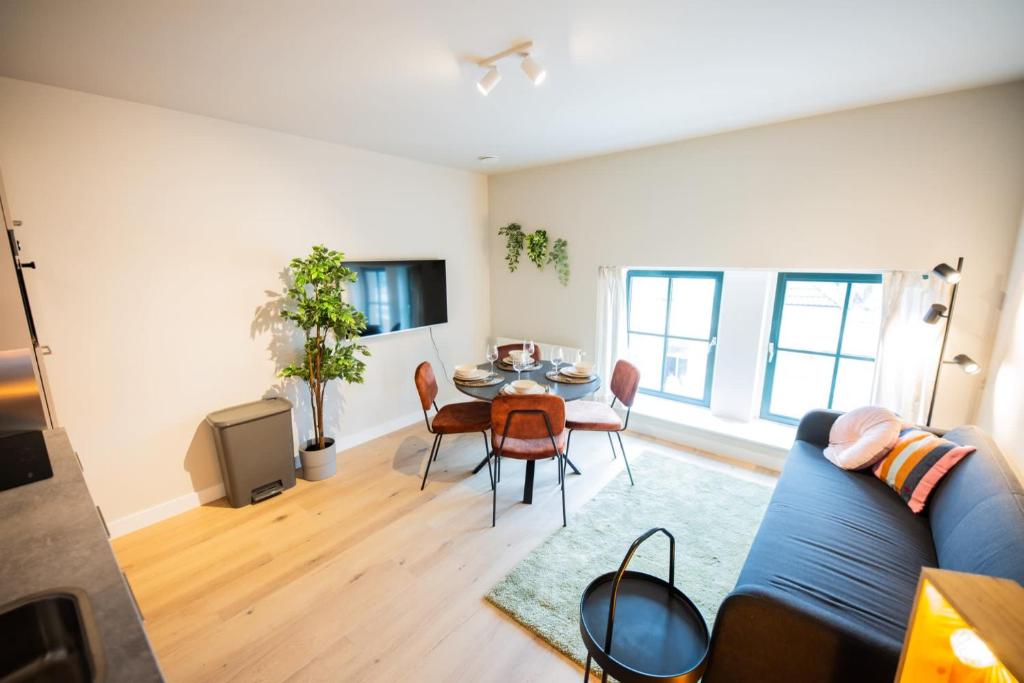 een woonkamer met een blauwe bank en een tafel bij Flawless 3 Bedroom Apartment in Rotterdam