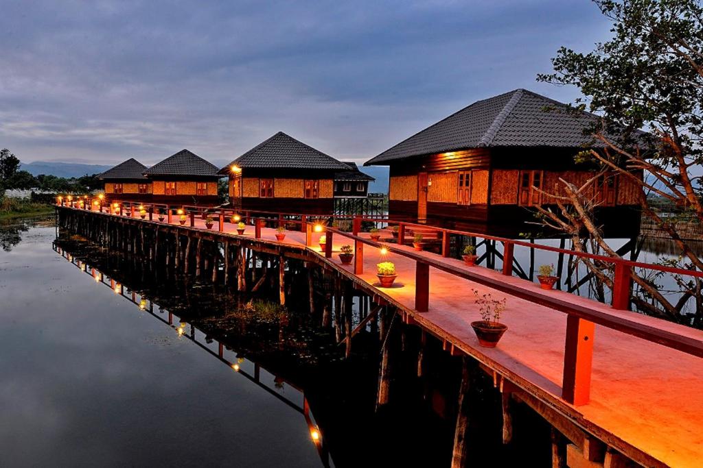 una fila de edificios sobre un puente sobre el agua en Shwe Inn Tha Floating Resort, en Ywama