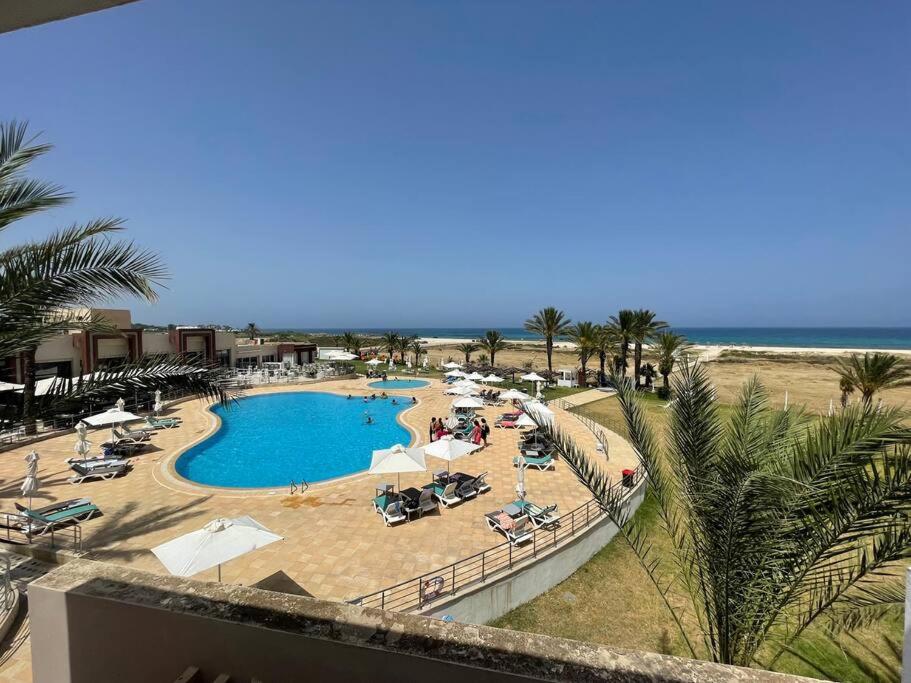 una vista aérea de una piscina en la playa en Beachfront Apartment 105- Hotel Andalucia, en Bizerte