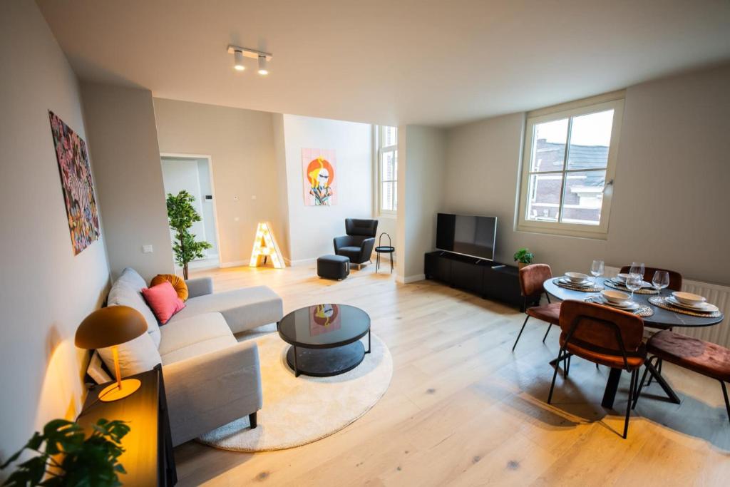 Ample 3 Bedroom Apartment في روتردام: غرفة معيشة مع أريكة وطاولة
