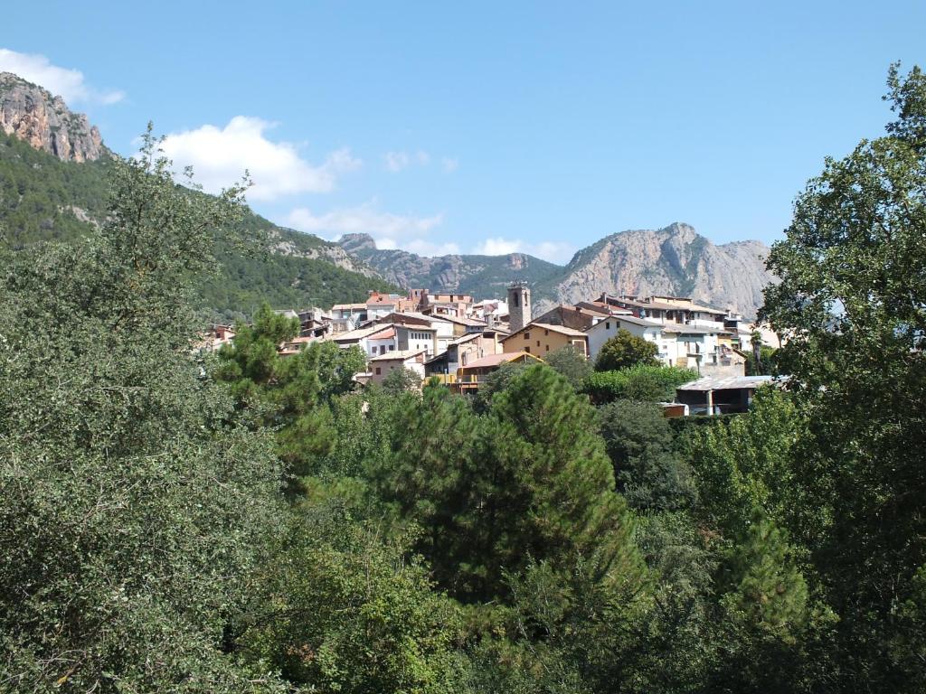 un pueblo en una colina con montañas en el fondo en La Llar de Peramola, en Peramola