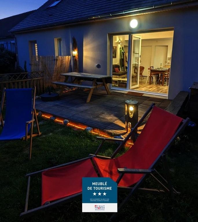 - une terrasse avec 2 chaises et une table de pique-nique dans la cour dans l'établissement Le Rocky Lodge Large cottage with wooden deck and private garden next to Fontainebleau Forest, à Achères-la-Forêt