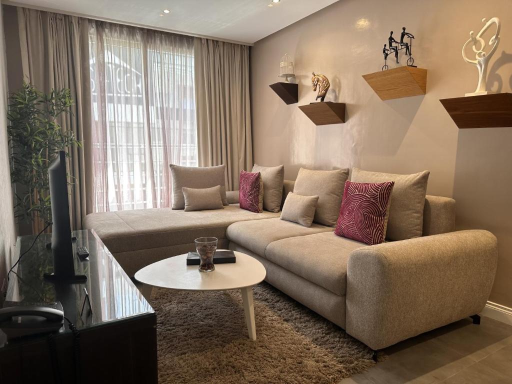 sala de estar con sofá y mesa en RENT-INN Suites Hotel en Rabat