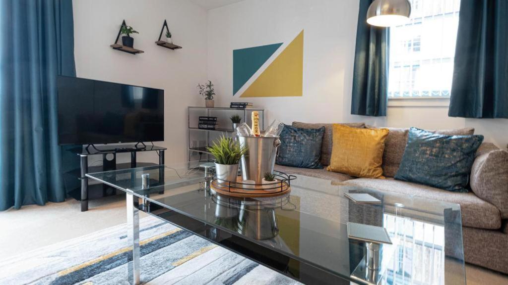 Quayside 2-Bed Apartment in Dundee في دندي: غرفة معيشة مع أريكة وطاولة زجاجية