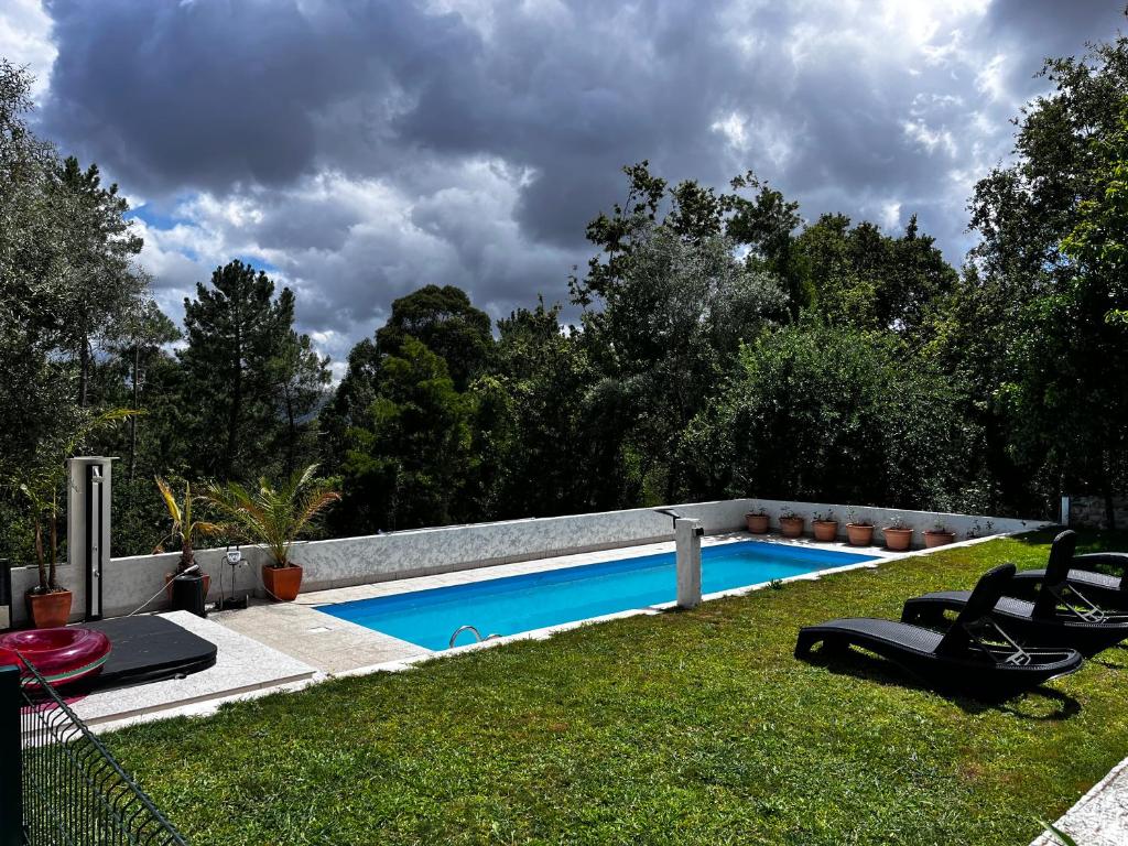 una piscina en un patio con 2 sillas de césped en Glamping de Cerveira en Vila Nova de Cerveira