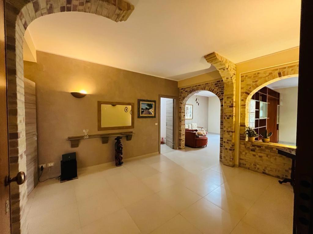 a large hallway with an archway and a living room at Casa Manila in Avola