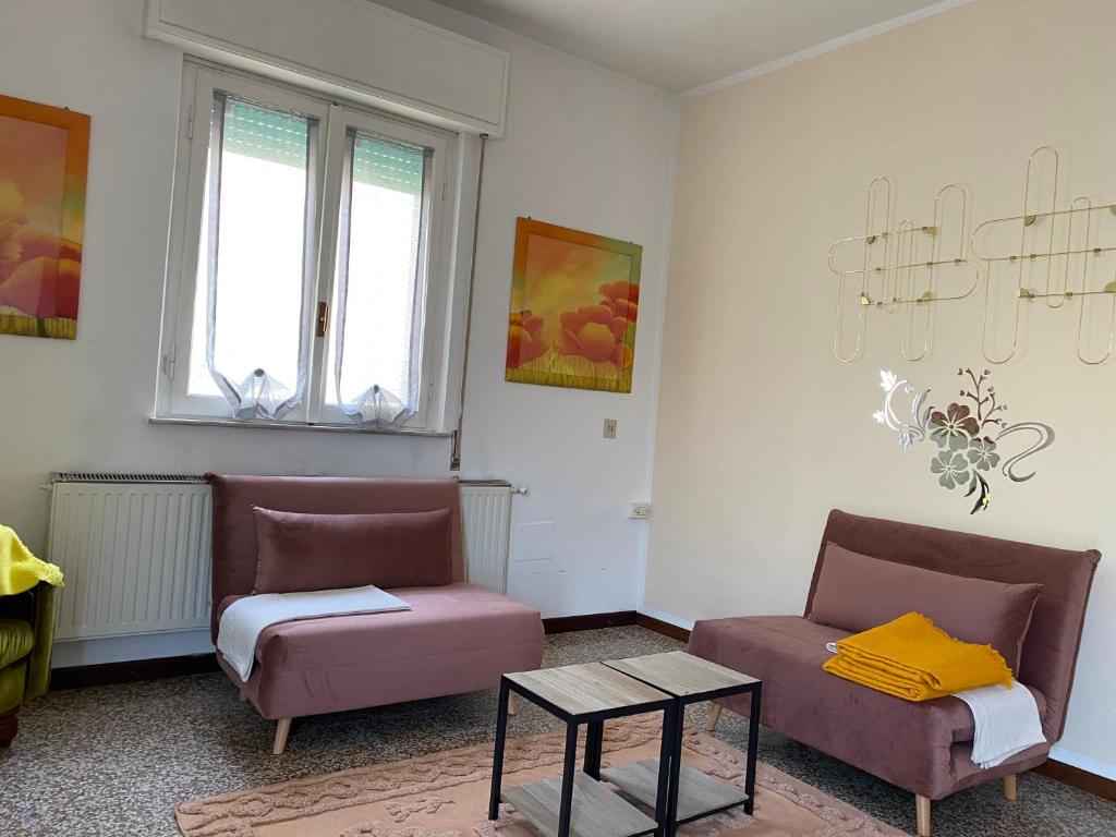 salon z 2 krzesłami i stołem w obiekcie Appartamento luminoso a due passi da Piacenza w mieście Caorso
