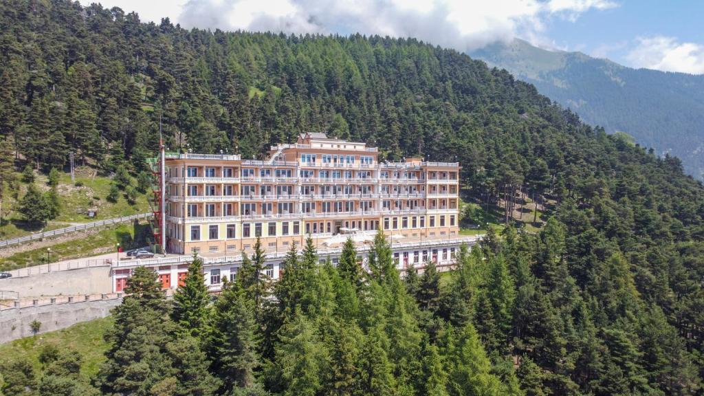 un grande edificio sul fianco di una montagna di Pràcatinat Hotel & Restaurant a Fenestrelle