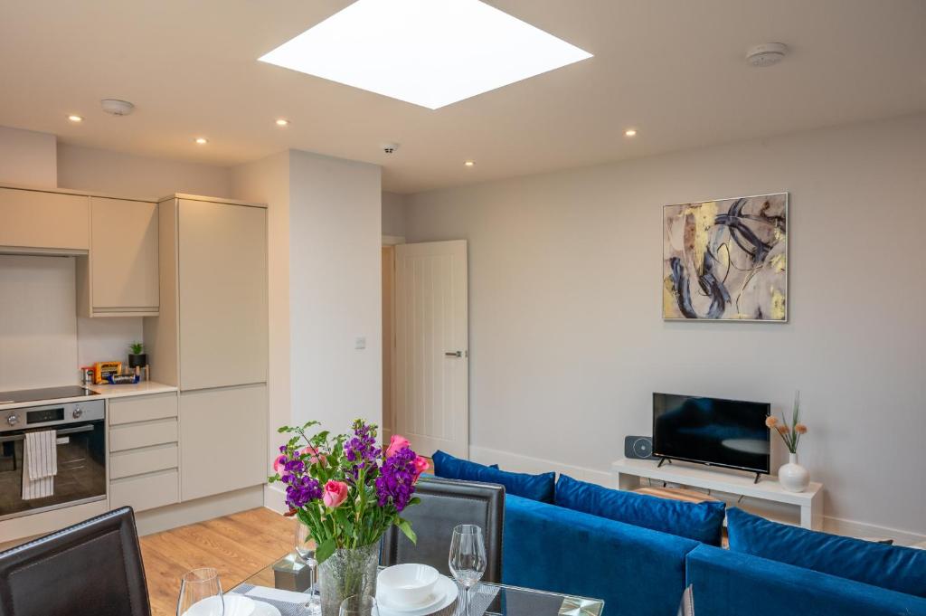 a living room with a blue couch and a table at Brand new Apartment by the Marina - Sleeps 4 in Ramsgate