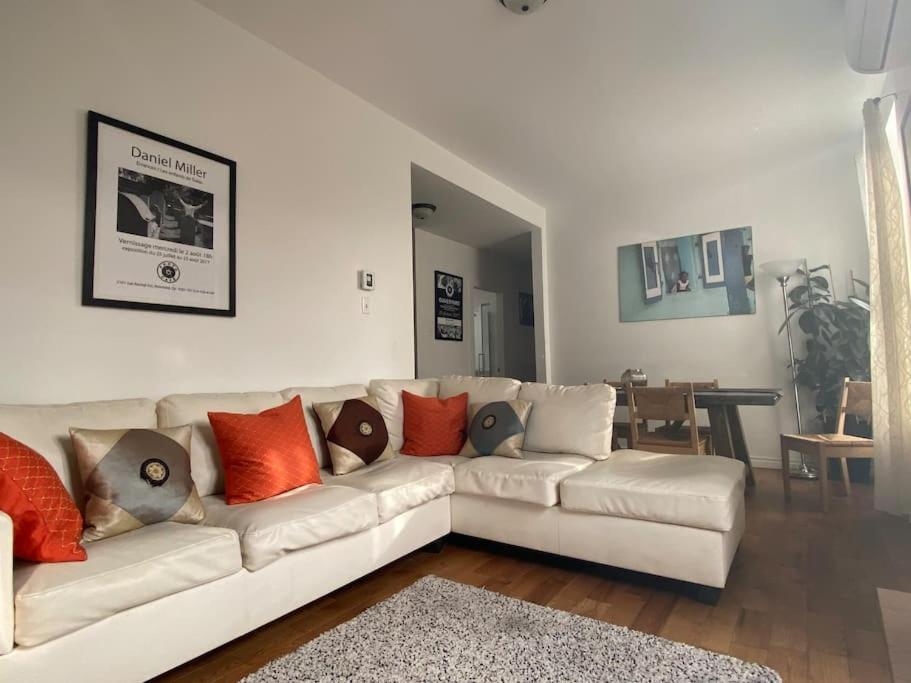 Bel Grand app.-Plateau Mont-Royal-No-CITQ 298319 في مونتريال: غرفة معيشة مع أريكة بيضاء مع وسائد عليها