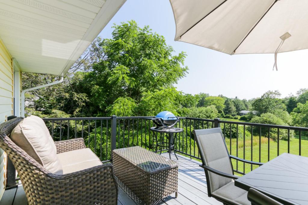a balcony with chairs and a table and an umbrella at Connecticut Retreat Steps to Historic Downtown! in Litchfield