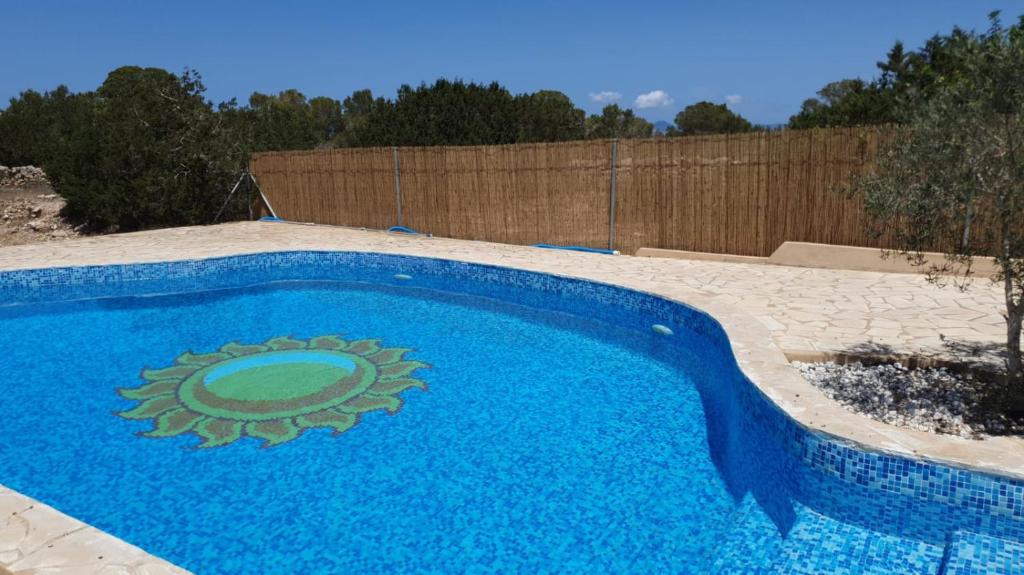 a blue swimming pool with a sun design on it at Els Castells in Illes Balears