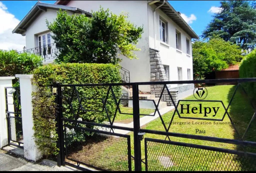 um portão com um sinal feliz em frente a uma casa em Maison Carcari em Pau