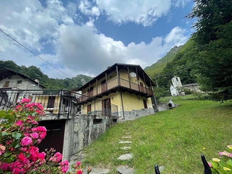 a house on a hill with flowers in front of it at Baita pressi Gran Paradiso in Sparone