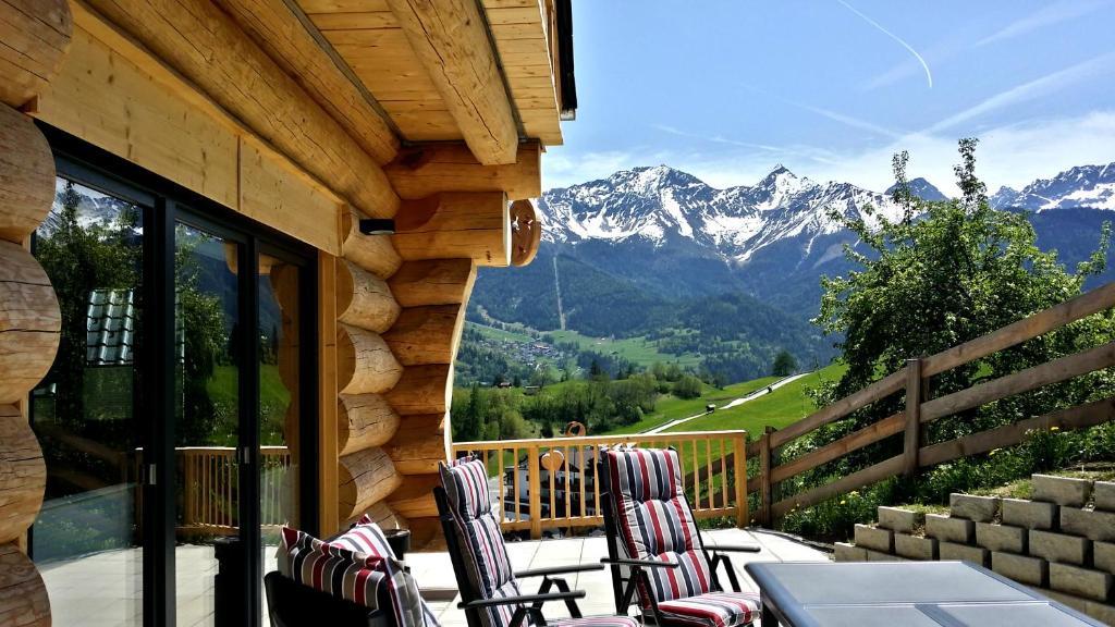 a table and chairs on a balcony with mountains at TyroLadis in Ladis