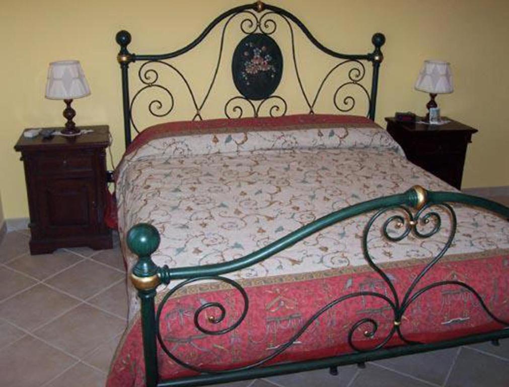 1 cama en un dormitorio con 2 mesitas de noche y 2 lámparas en B&B Villa Rosalia, en Barrafranca