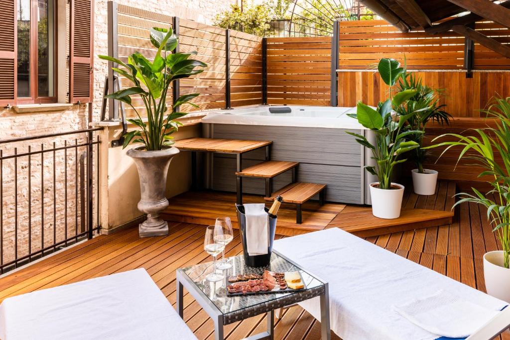 um deque com uma banheira e uma mesa em GG8 Hotel & Suite SPA em Gualdo Tadino
