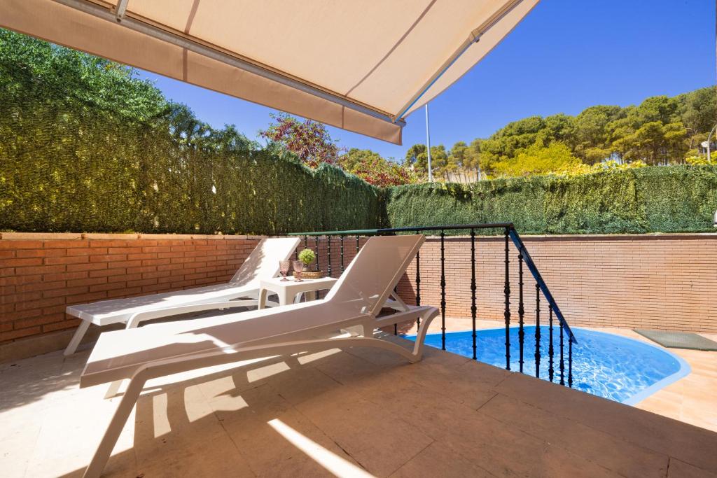 a white chair sitting on a patio next to a swimming pool at CASA CON PISCINA EN EL CENTRO in Tudela