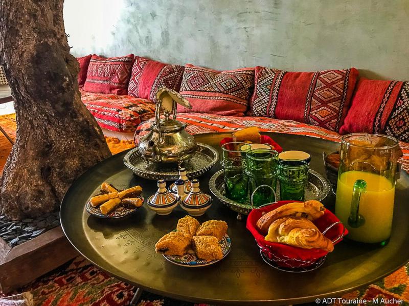 a table with plates of food and drinks on a couch at Riad SPA &quot;Les Portes de l&#39;Orient&quot; TOURS in Tours