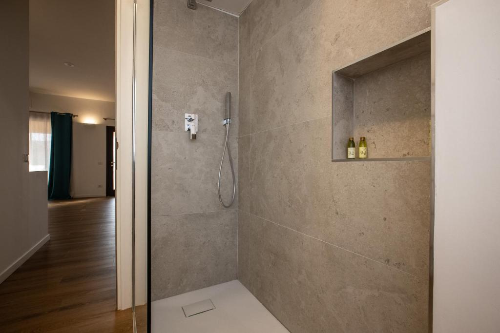 bagno con doccia e porta in vetro di Il Borgo Boutique Rooms by KasaVacanze a Porto San Paolo