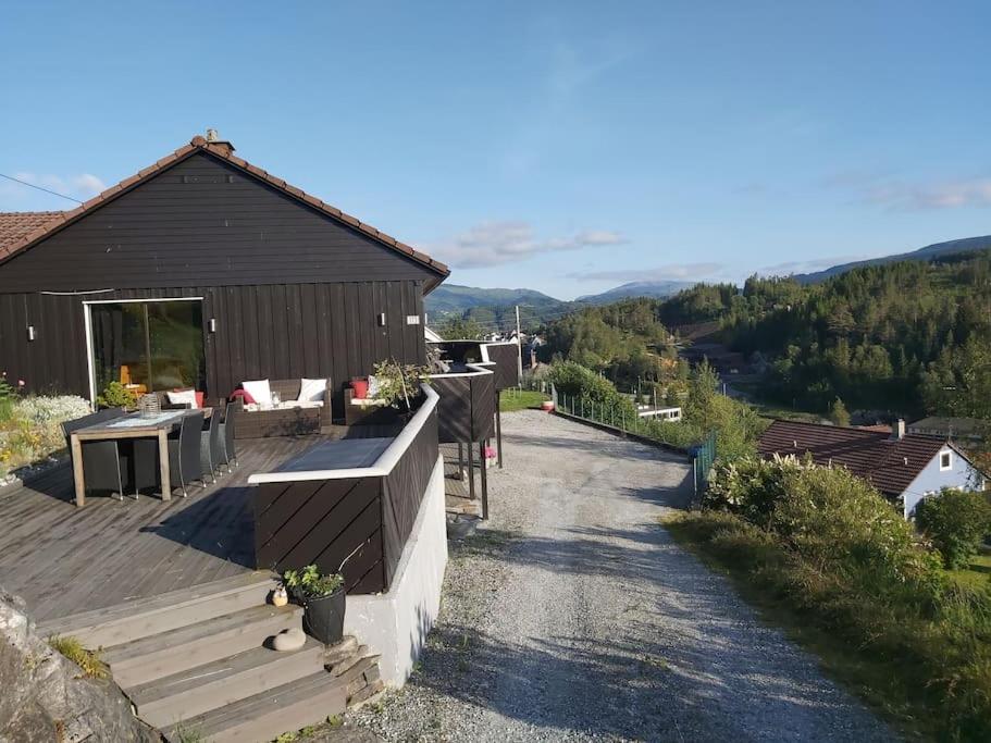 una casa con terraza y un edificio en Casa Monami Leilighet i naturen nær Bergen, en Lonevåg