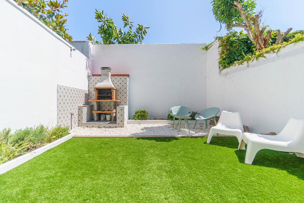 a garden with a fireplace and green grass at Casa Premia in Premiá de Mar