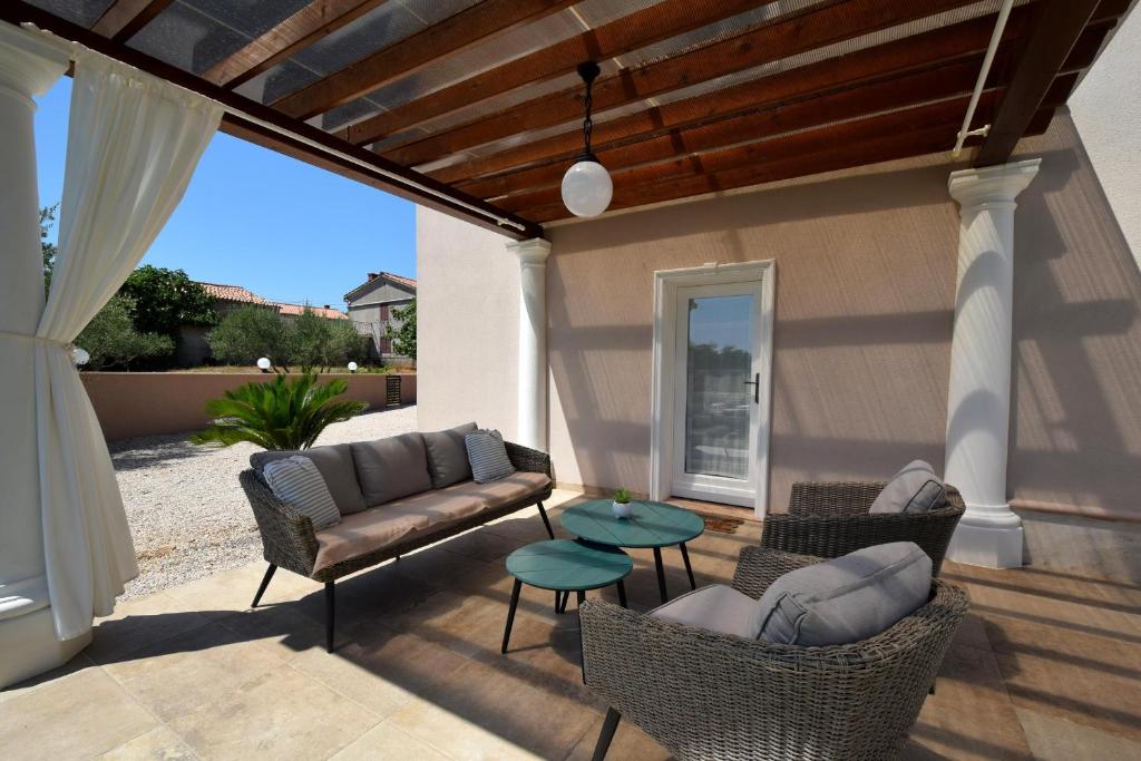 a patio with a couch and chairs and a table at Villa Frana in Krk