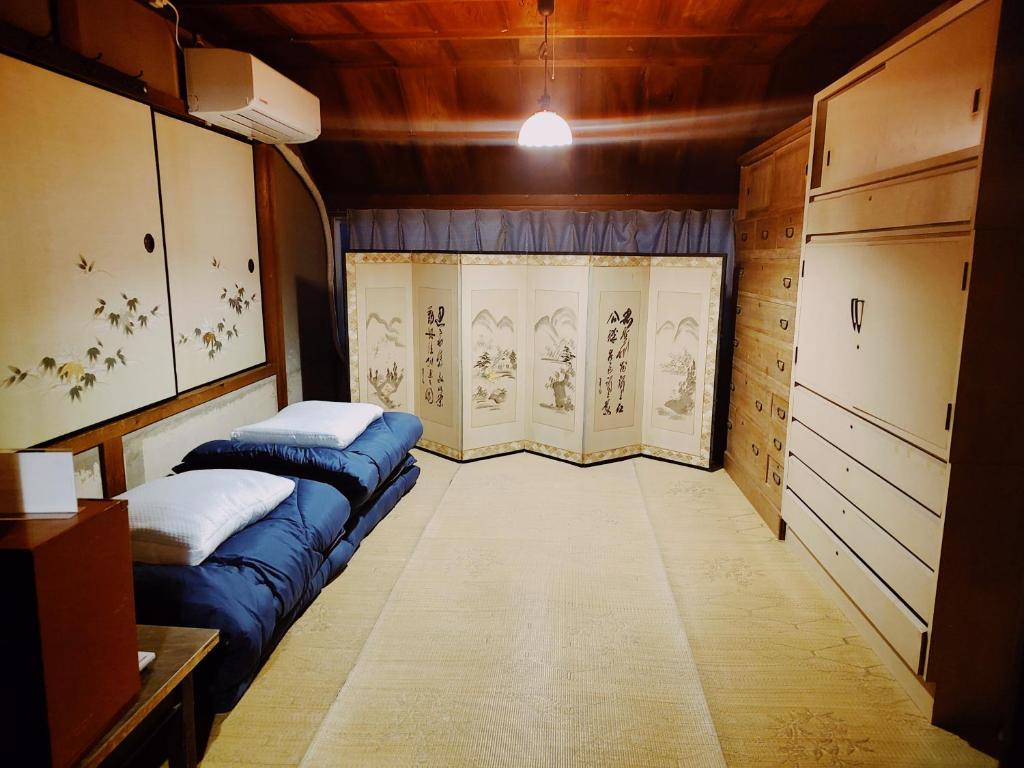 Habitación pequeña con 2 camas y ventana en Fukubatake B&B, en Yoshino