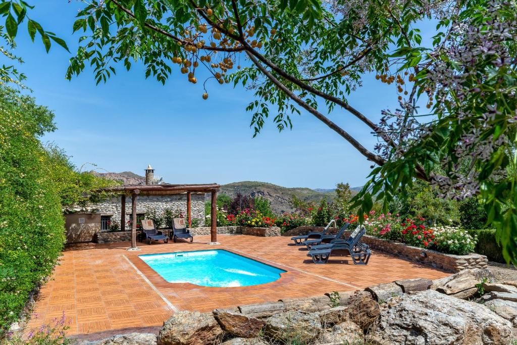 um quintal com uma piscina e um gazebo em Alpujarra Sulayr em Pórtugos