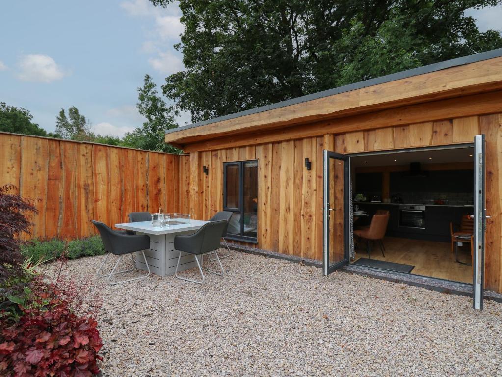 een houten schuur met een tafel en stoelen erin bij Celyn in Welshpool