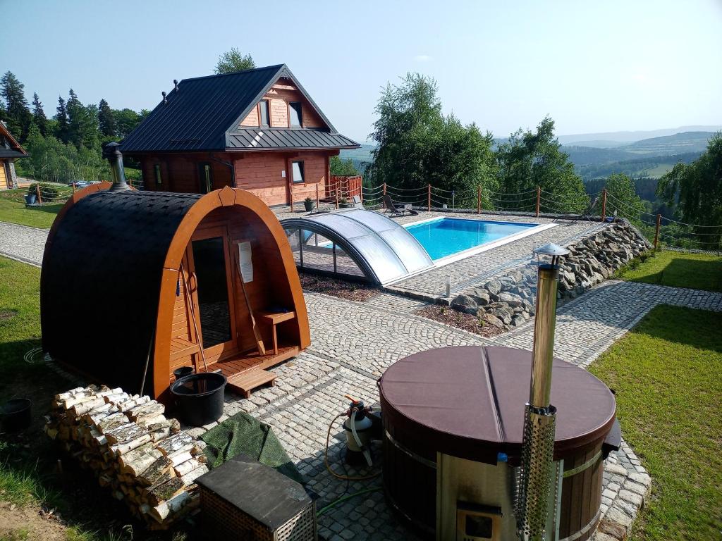 een leguaanhuis met een tafel en een zwembad bij Sowiogórska Ostoja in Jugów