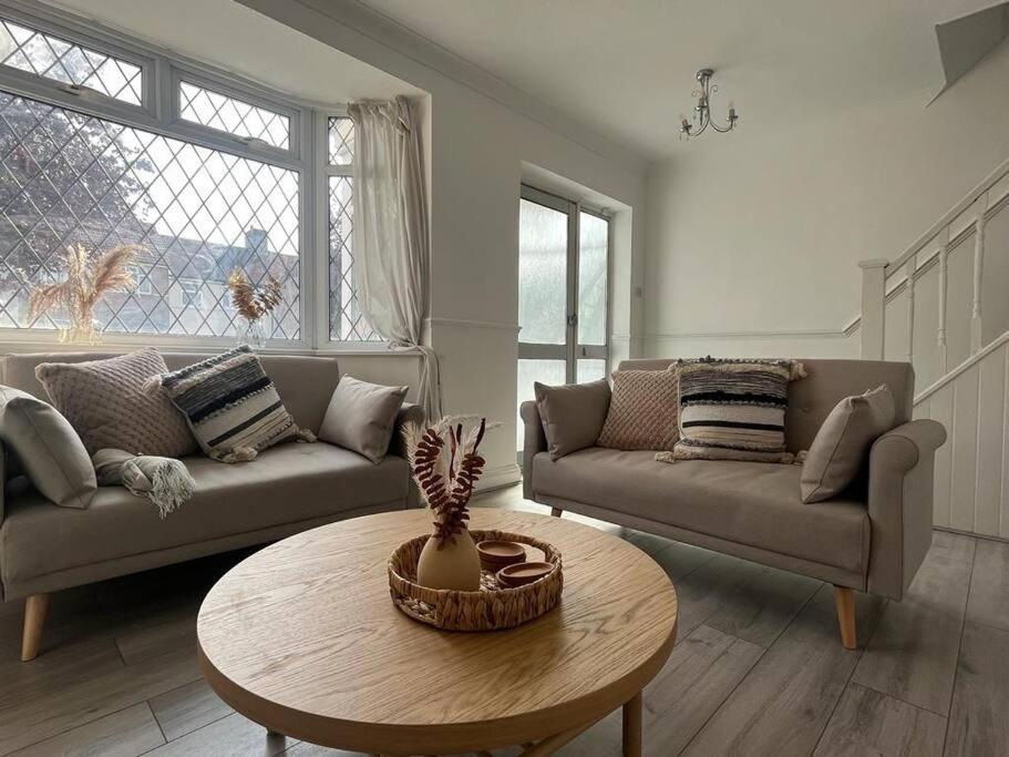 a living room with two couches and a table at Beautiful house/Parking in Plumstead