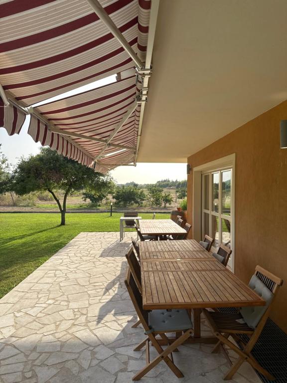 patio ze stołem i krzesłami pod markizą w obiekcie Villa Arzilla Sardegna w mieście Alghero