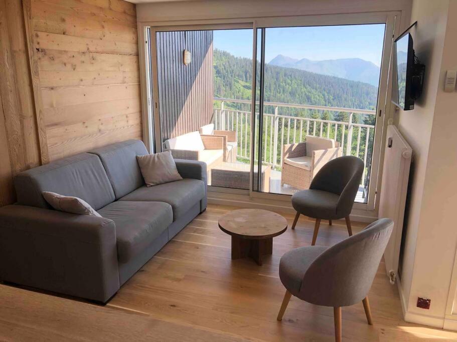 un salon avec un canapé et une grande fenêtre dans l'établissement 3 pièces, 6 personnes, à Chamrousse