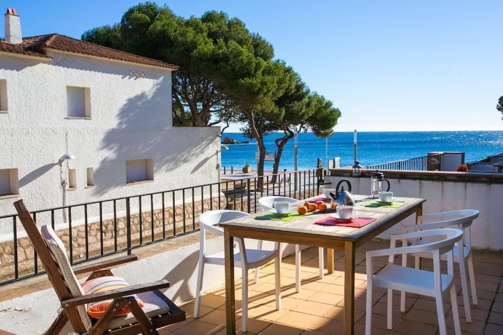 un tavolo e sedie su un balcone con vista sull'oceano di Salitres Increíbles vistas a 50m de la playa a Tamariu