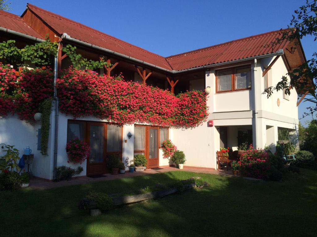 una casa con flores a un lado. en Ida panzió, en Lajosmizse