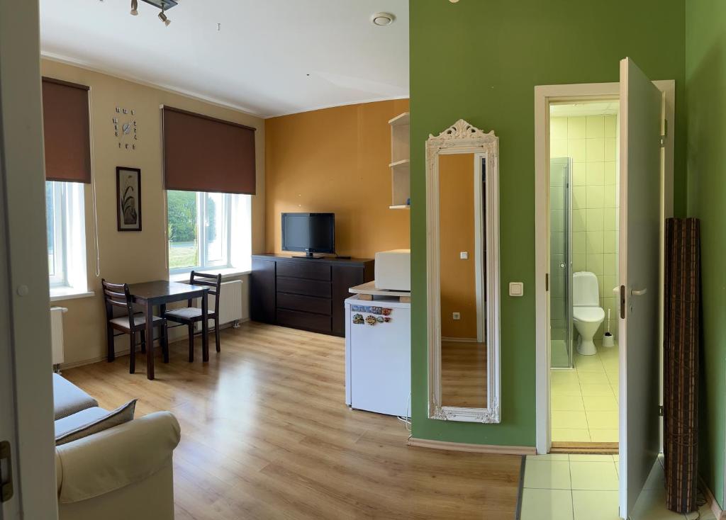 a kitchen and living room with green walls and a table at Mõisavälja 10 apartment in Rakvere