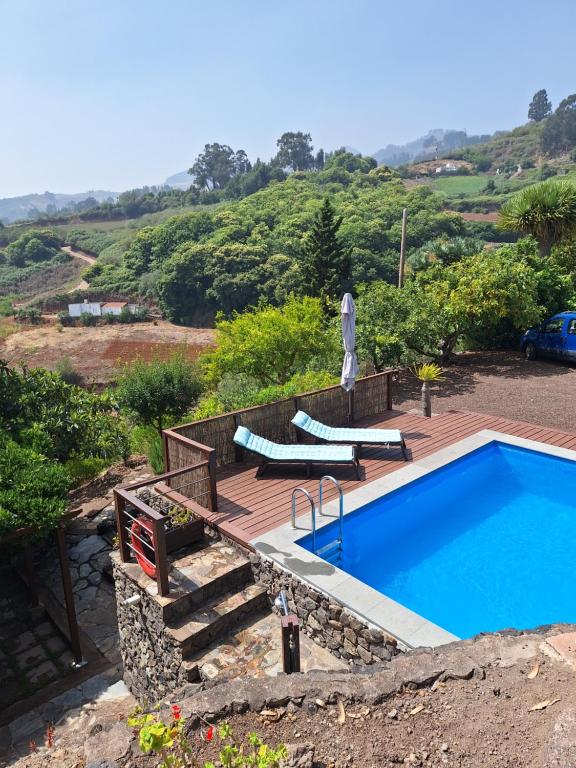 a swimming pool on a wooden deck next to at CASA RURAL CON PISCINA PRIVADA El ROBLE in Moya