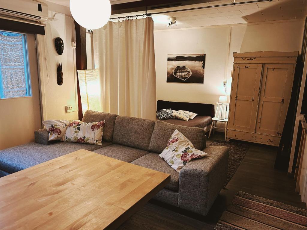 ein Wohnzimmer mit einem Sofa und einem Tisch in der Unterkunft Small Apartment, Tahko, Sauna, Shower, WiFI, PetsOK, Budget, Wanha koulu Tahkovuori in Reittiö