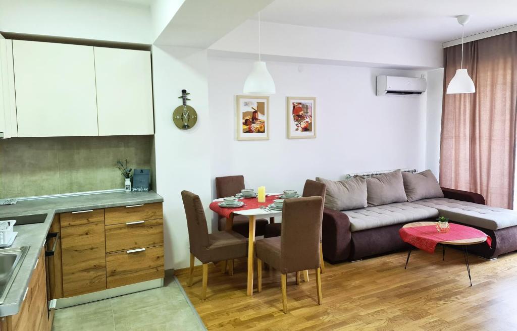 een keuken en een woonkamer met een bank en een tafel bij Skopje Center City Apartment 3 in Skopje